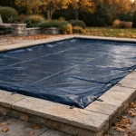 Bâche hivernage bleue installée sur une piscine rectangulaire 8x4 entourée de margelles