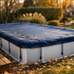 Bâche d'hivernage bleue tendue sur piscine hors sol dans jardin automnal