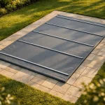 Bâche à barres grise installée sur une piscine rectangulaire 8x4 dans un jardin
