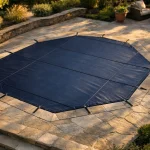 Bâche à barres bleue sur piscine hexagonale dans un jardin résidentiel